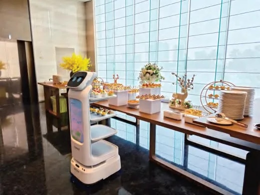 Robot CADEBOT ob mizi s hrano pri panoramskem oknu