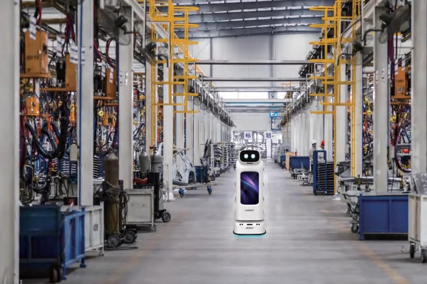 Robot CADEBOT v proizvodni hali med visokimi regali
