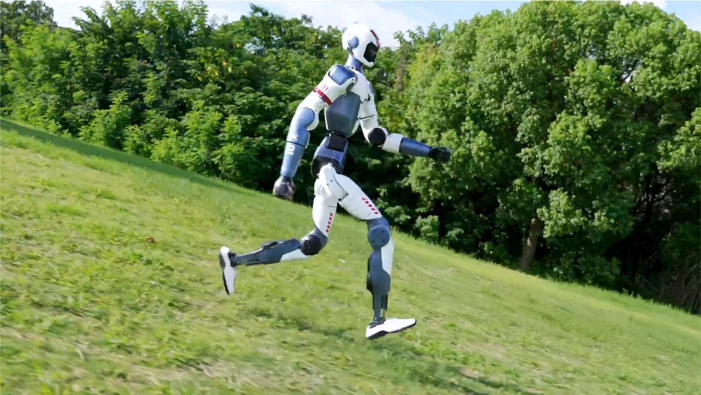 Robot R1 teče po travnatem pobočju