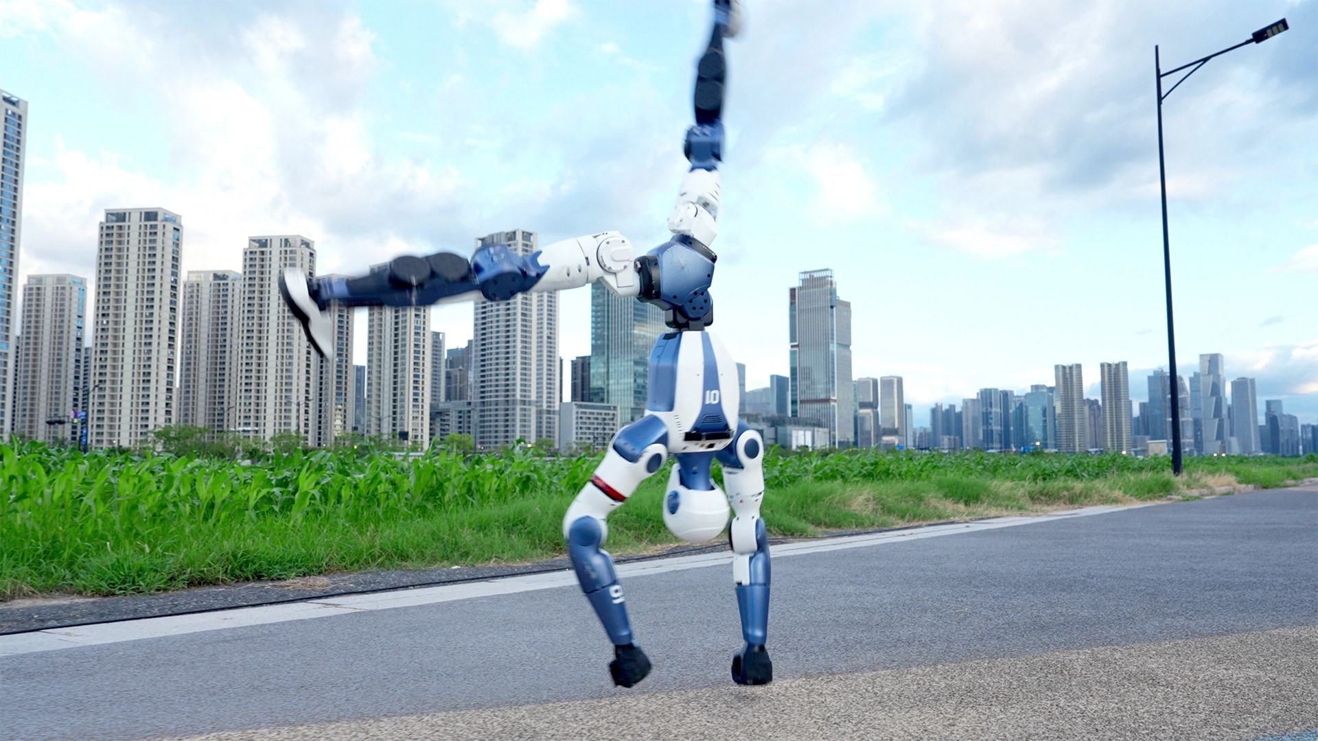 Robot R1 hodi po rokah po cesti pred mestnim obzorjem
